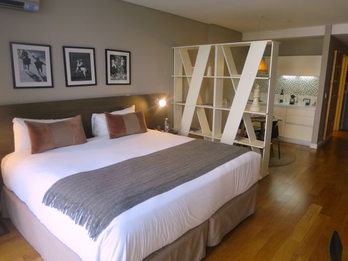 A bedroom with a bed and chair in a room Description automatically generated