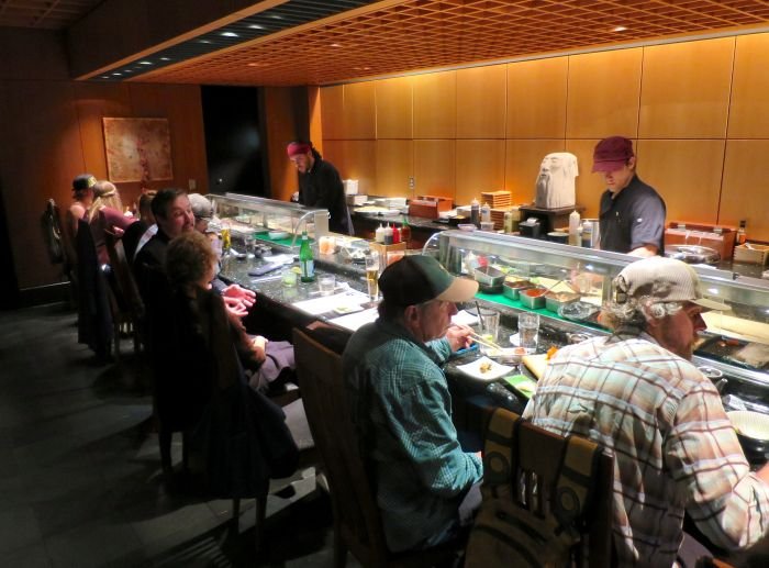 A group of people preparing food in a kitchen Description automatically generated