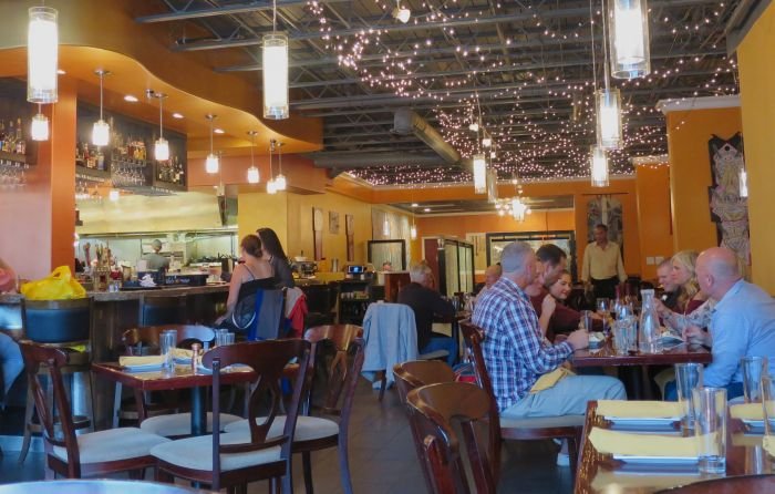 A group of people sitting at a table in a restaurant Description automatically generated