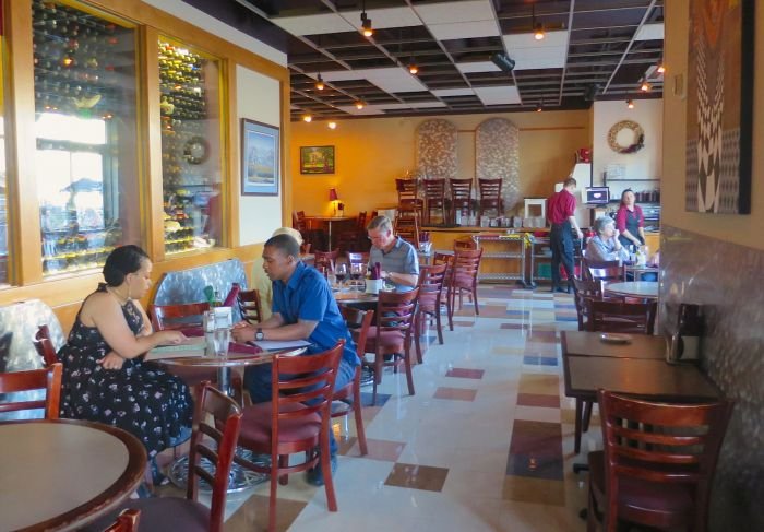 A group of people sitting at a table in a restaurant Description automatically generated