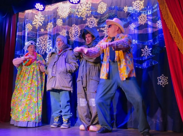 A group of people standing on a stage in front of a curtain Description automatically generated