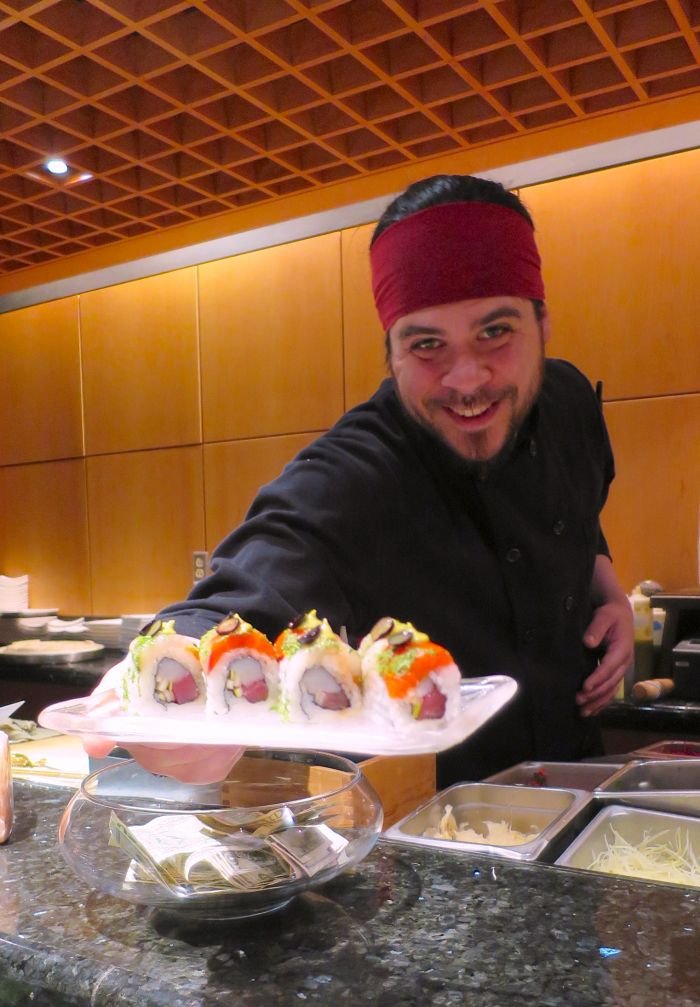 A person sitting at a table with food Description automatically generated