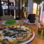 A plate of pizza and a glass of wine Description automatically generated