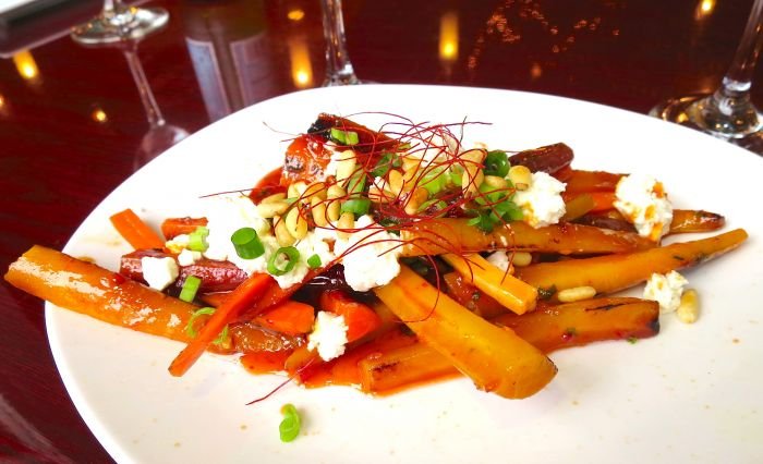 A white plate topped with meat and vegetables Description automatically generated