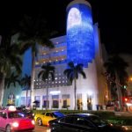 A car parked on a city street filled with traffic at night Description automatically generated