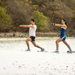A group of people playing frisbee on the beach Description automatically generated
