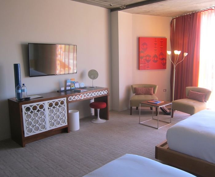 A bedroom with a bed and desk in a room

Description automatically generated