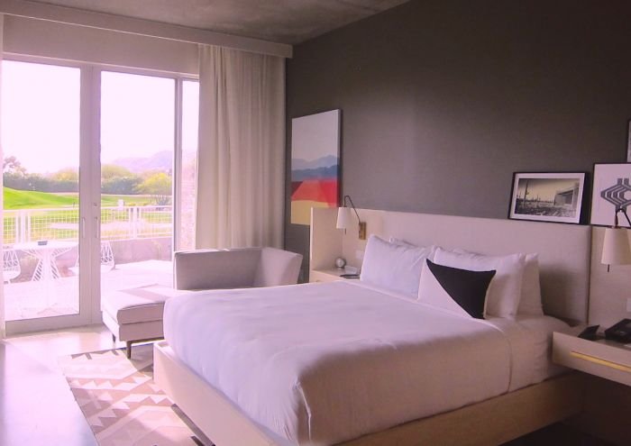 A bedroom with a large bed in a hotel room

Description automatically generated