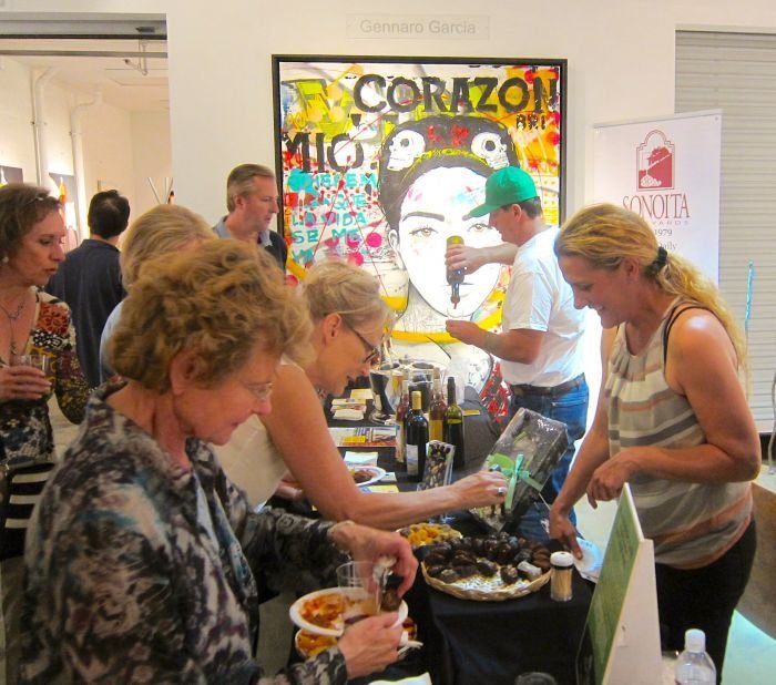 A group of people standing in a kitchen preparing food Description automatically generated