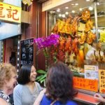 A group of people standing in front of a store Description automatically generated