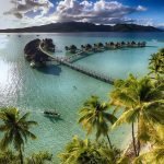 A large body of water surrounded by palm trees Description automatically generated