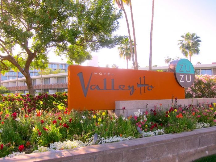 A sign on an orange flower

Description automatically generated