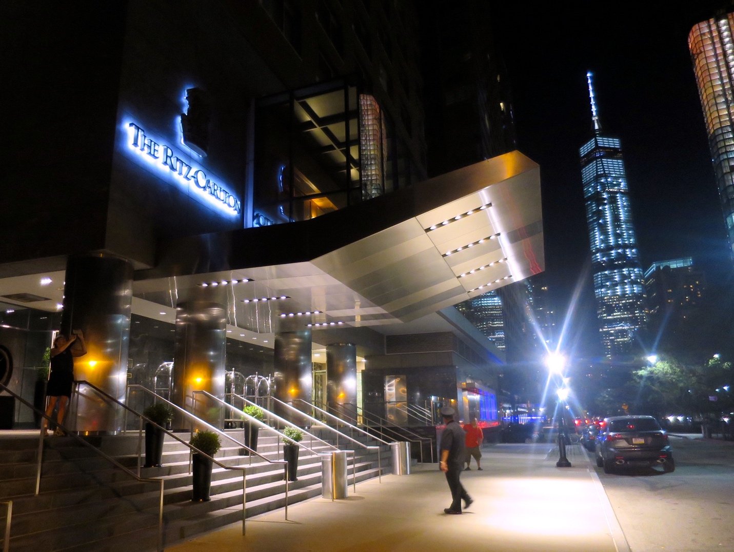 A group of people walking on a city street at nightDescription automatically generated