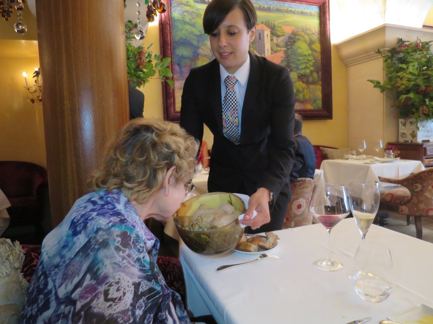 Two people sitting at a table eating foodDescription automatically generated